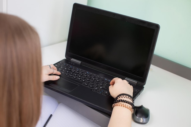 Un adolescente se sienta y escribe mientras hace la tarea