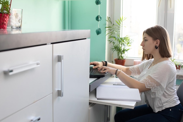 Un adolescente se sienta frente a una computadora portátil con la intención de aprender a vivir en línea