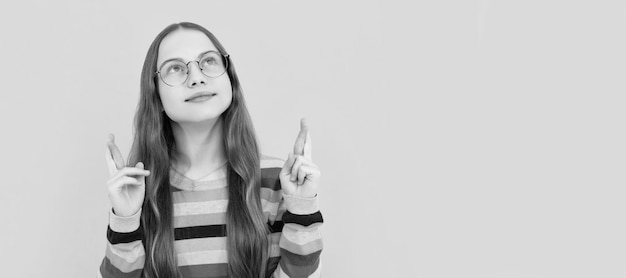 Adolescente sonhadora com óculos fazendo um desejo de volta à escola conhecimento e educação rosto de criança cartaz horizontal adolescente isolado bandeira de retrato com espaço de cópia