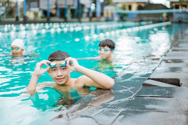 Un adolescente sonríe mientras se quita las gafas de natación