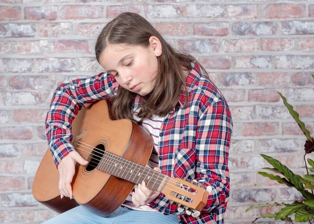 Adolescente sonriente tocando la guitarra