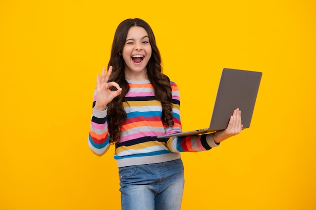 Adolescente sorprendida Estudiante colegiala con laptop en estudio aislado Video webinar en línea aprender en laptop elearning lección pc computadora llamada Colegiala adolescente emocionada