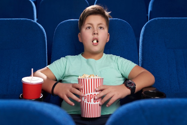 Adolescente sorprendido con la boca abierta viendo películas en el cine