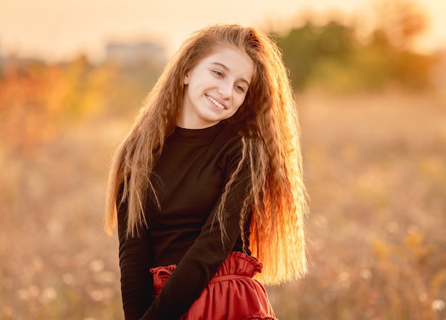 Adolescente sorridente em campo de outono