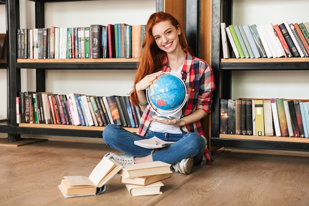 Adolescente sorridente segurando um globo