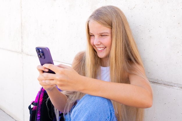 Foto adolescente sorridente usando telefone celular ao ar livre