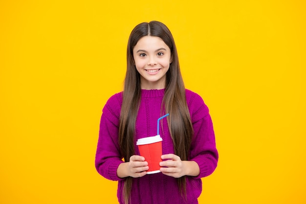 Adolescente con una taza para llevar de café capuchino o té Niño con una taza para llevar sobre fondo amarillo bebida de la mañana