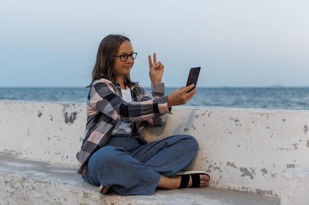 Adolescente tira uma selfie na praia