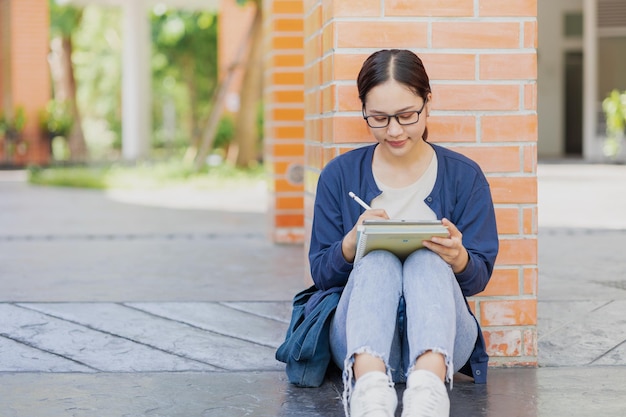 Una adolescente universitaria feliz en el campus de la escuela disfruta del aprendizaje de la educación de los asiáticos femeninos