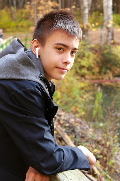 Adolescente usando audífonos en el parque