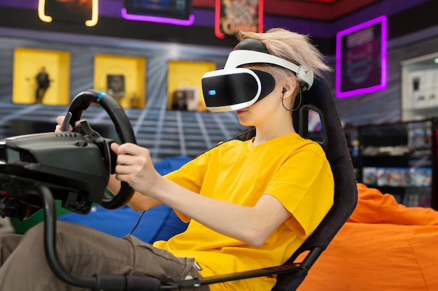 Adolescente usando óculos de realidade virtual, que se segura no volante e joga um jogo de computador no console