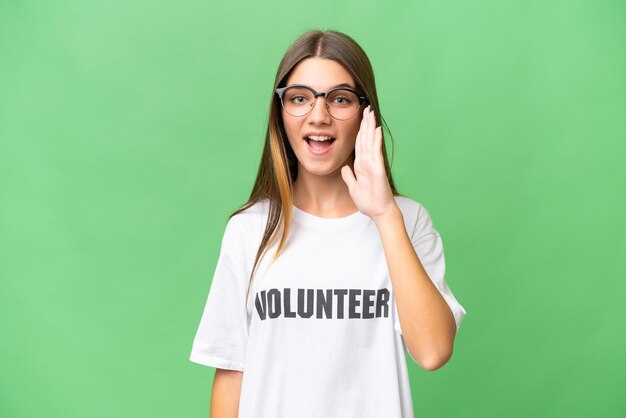 Adolescente voluntaria chica caucásica sobre fondo aislado gritando con la boca abierta