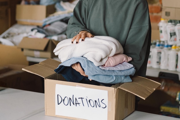 Adolescente voluntário preparando caixas de doação para pessoas Doação de roupas para refugiados apoio às vítimas da guerra Conceito de ajuda humanitáriaAjudando as pessoas