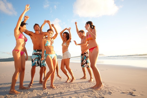 Foto adolescentes alegres bailando en la playa retrato de adolescentes felices bailando en la playa