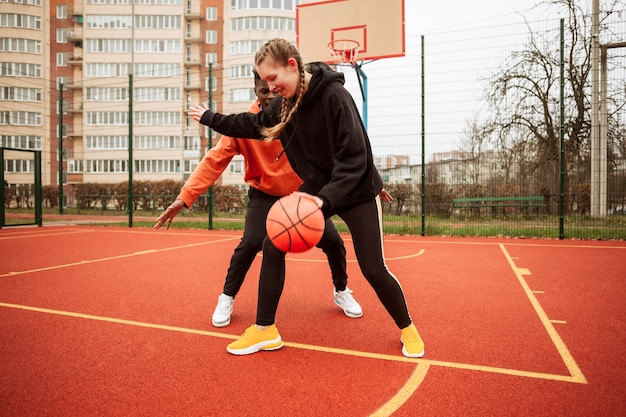 Foto adolescentes en el campo de baloncesto juntos