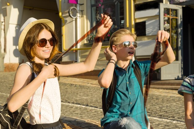 Adolescentes com interesse e surpresa assistindo negativos de fotos de filmes