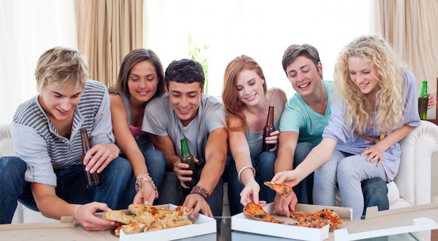 Adolescentes comiendo pizza en casa