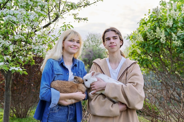 Adolescentes con conejos en sus manos mascotas un par de conejos decorativos