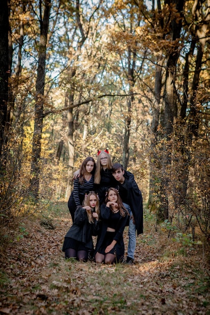 Adolescentes em trajes de halloween na floresta