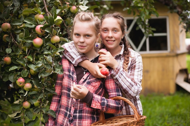 Adolescentes felices en camisas a cuadros en verano en el jardín