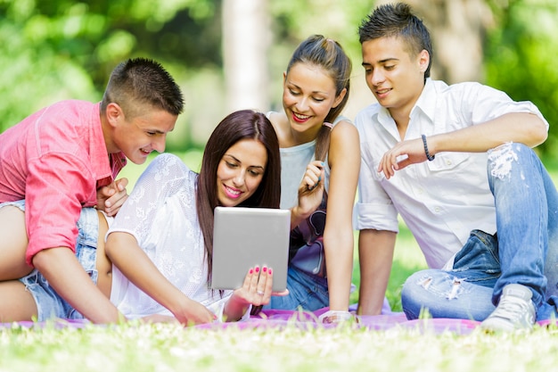 Adolescentes en el parque con tableta