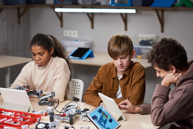 Adolescentes proyectando robots en computadoras