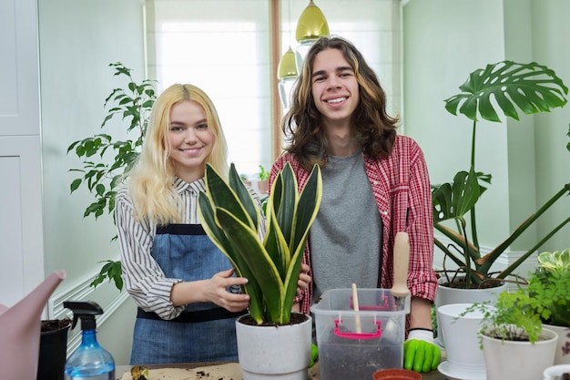 Adolescentes rapaz e garota plantando planta de casa em pote