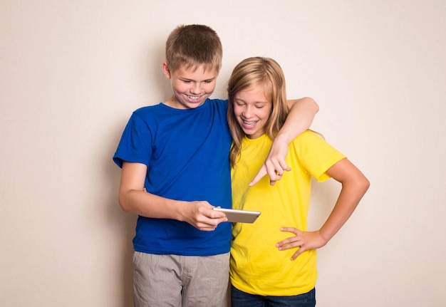 Adolescentes se divertindo com telefones celulares Estilo de vida moderno e conceito de tecnologia Crianças assistindo foto ou vídeo no smartphone