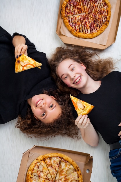 Adolescentes segurando uma caixa de pizza e sorrindo. conceito de entrega de pizza.