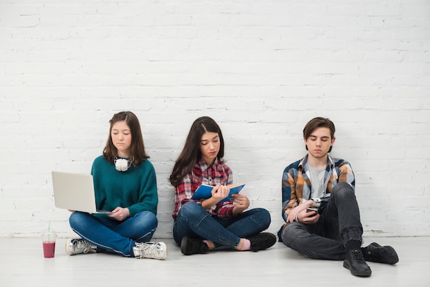 Foto adolescentes sentados en el suelo