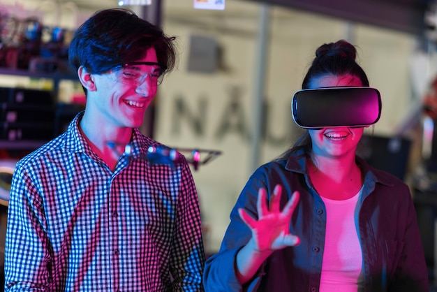 Adolescentes sonrientes haciendo experimentos de robótica en un laboratorio Niño con gafas protectoras y niña en realidad virtual