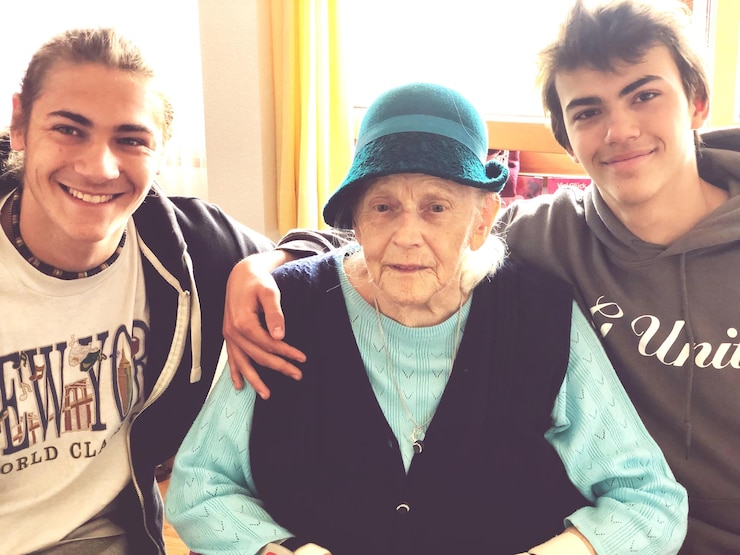 Foto adolescentes sonrientes sentados con la abuela en casa