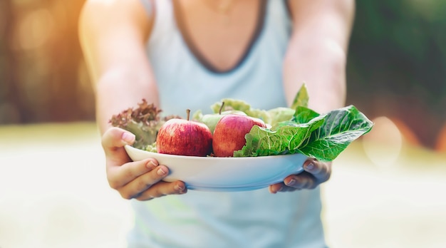 Adolescentes sosteniendo un plato con frutas, verduras, comer sano