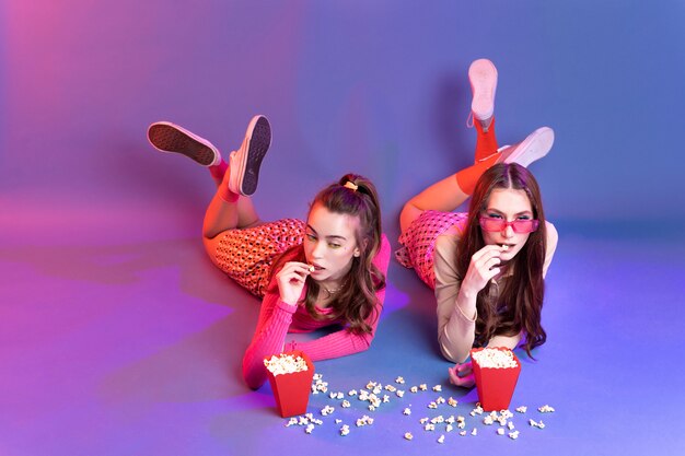 Foto adolescentes de tiro completo comiendo palomitas de maíz