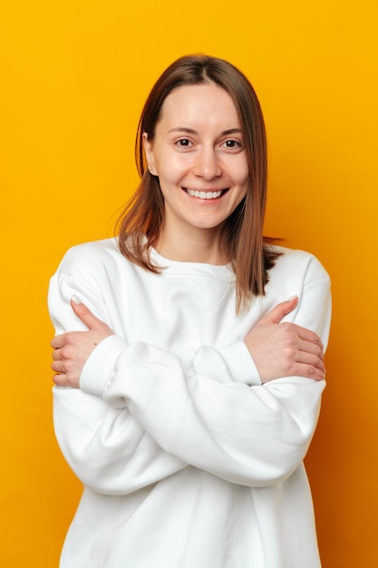 Adopte el concepto de equidad en el retrato de una mujer sonriente que se abraza a sí misma