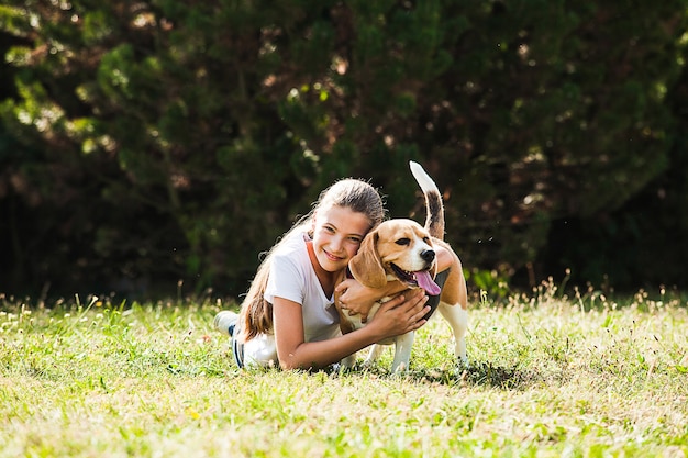 Adorable adolescente juega con perro beagle en el parque