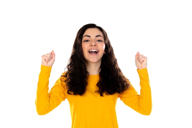 Adorable adolescente con suéter amarillo aislado en una pared blanca