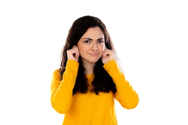 Adorable adolescente con suéter amarillo aislado en una pared blanca