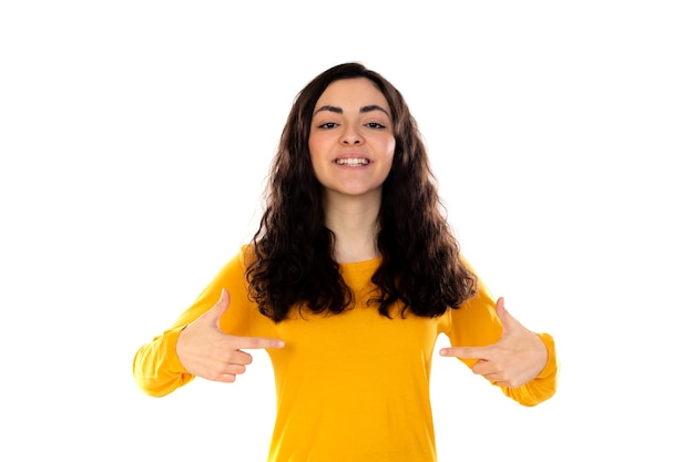 Adorable adolescente con suéter amarillo aislado en una pared blanca