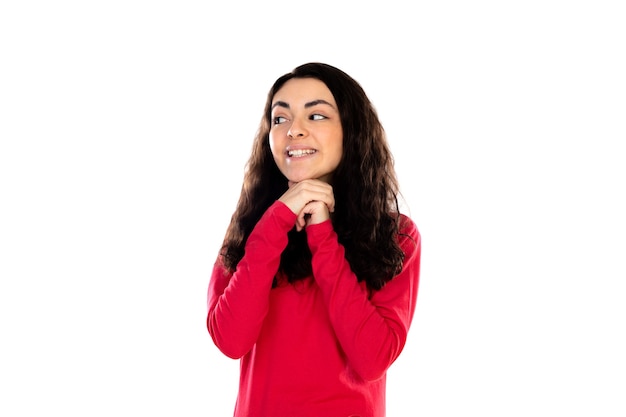 Adorable adolescente con suéter rojo aislado en una pared blanca