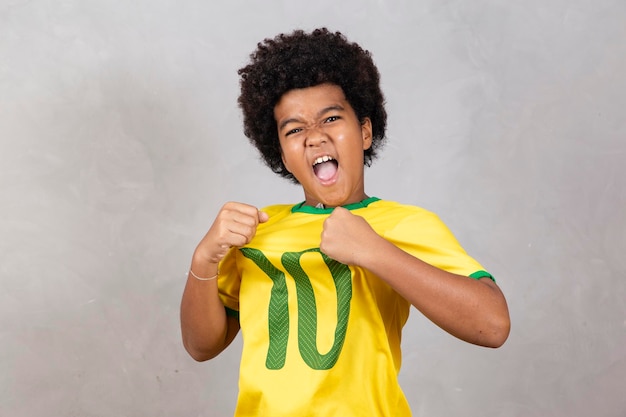 Adorable afro boy fan brasileño celebrando