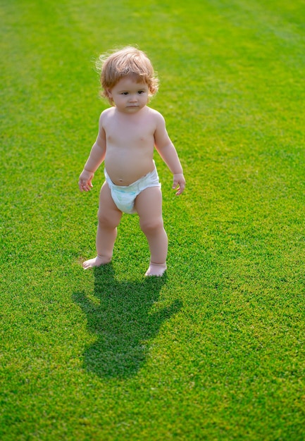 Adorable bebé al aire libre posando sobre hierba verde retrato de verano de niño hermoso en el césped