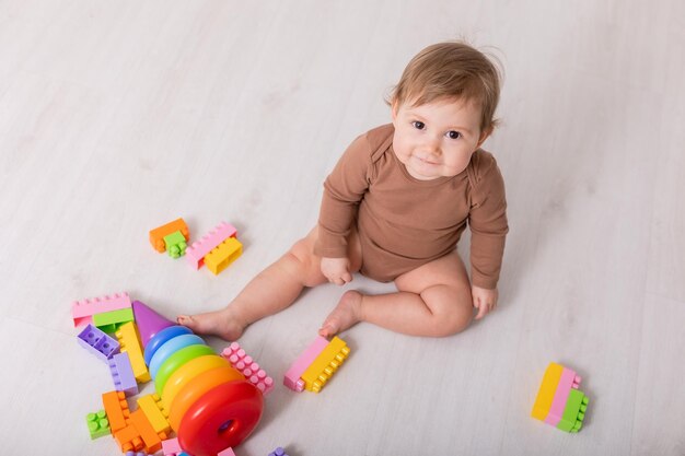 adorable bebé en camisa marrón jugando con juguetes espacio de cartel de pancarta para el texto