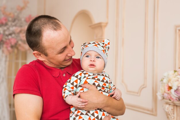 Adorable bebé caucásico y su padre. Retrato de un niño de tres meses.