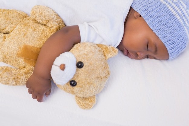 Adorable bebé durmiendo pacíficamente con teddy