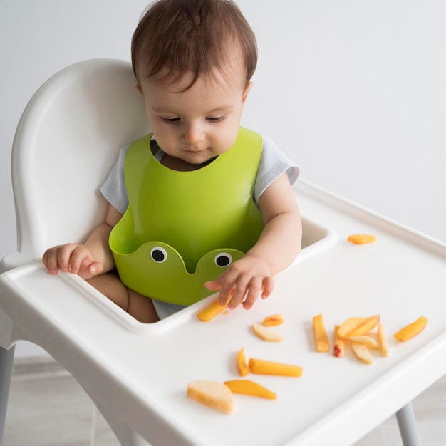 Foto adorable bebé jugando con comida