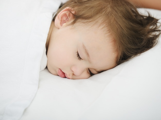 Adorable bebé con mamá en la cama