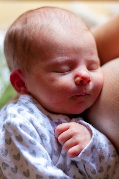 un adorable bebé recién nacido duerme en el pecho de su madre después de amamantar