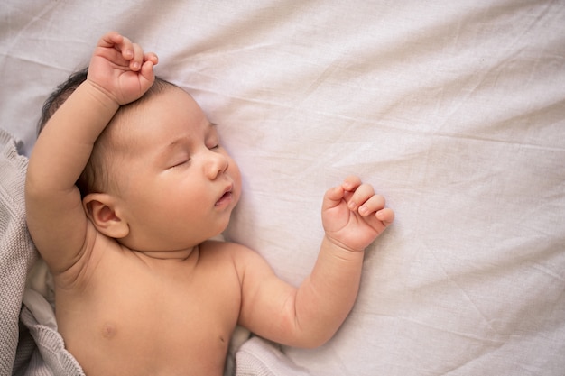 Adorable bebé recién nacido durmiendo con el estómago