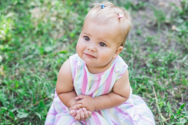 adorable bebé con vestido multicolor en el parque